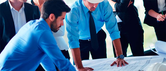 Grupo de trabajo revisando planos sobre una mesa